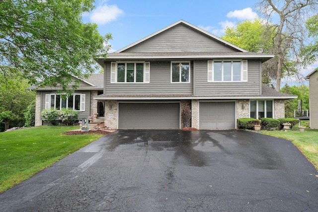 tri-level home with brick siding, an attached garage, a front yard, driveway, and roof with shingles