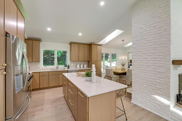 745 Virginia Shores Cir, Victoria, MN 55331 - kitchen featuring appliances with stainless steel finishes, a kitchen breakfast bar, light wood-type flooring, healthy amount of natural light, and brick wall