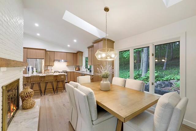 745 Virginia Shores Cir, Victoria, MN 55331 - dining room with a skylight, lofted ceiling, a brick fireplace, a chandelier, and recessed lighting