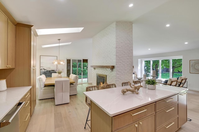 745 Virginia Shores Cir, Victoria, MN 55331 - kitchen with light wood finished floors, open floor plan, a kitchen breakfast bar, lofted ceiling, and a brick fireplace