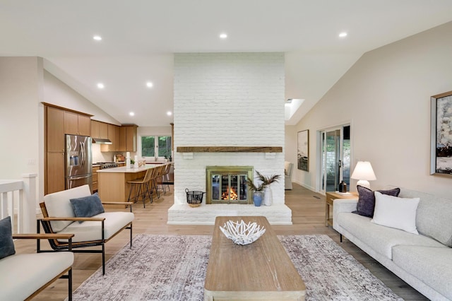 745 Virginia Shores Cir, Victoria, MN 55331 - living area with recessed lighting, high vaulted ceiling, a fireplace, and light wood-style floors