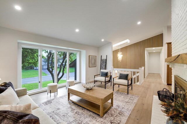 745 Virginia Shores Cir, Victoria, MN 55331 - living room with healthy amount of natural light, light wood finished floors, an accent wall, a chandelier, and recessed lighting