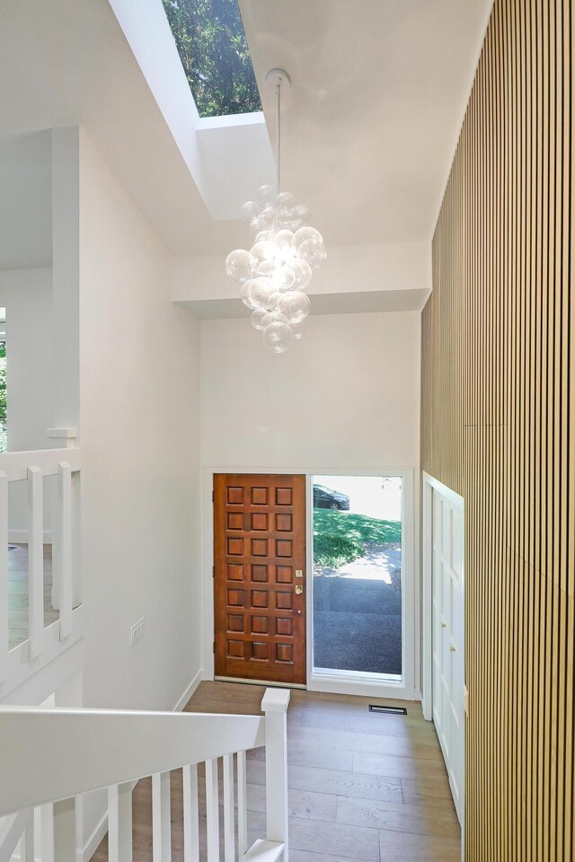 745 Virginia Shores Cir, Victoria, MN 55331 - entrance foyer with a chandelier, wood-type flooring, a skylight, and healthy amount of natural light
