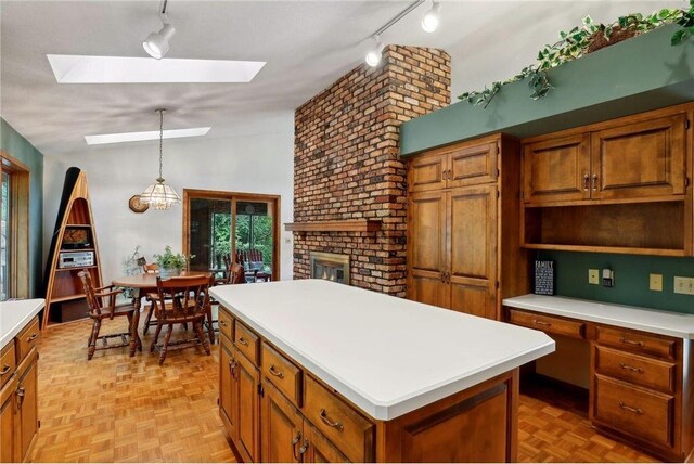 745 Virginia Shores Cir, Victoria, MN 55331 - kitchen with track lighting, a center island, brown cabinets, light countertops, and a fireplace