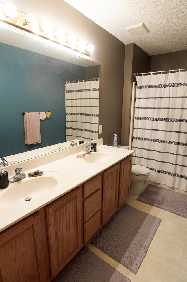 9467 Golden Eagle Ln, Monticello, MN 55362 - bathroom with double vanity, toilet, a shower with curtain, a textured ceiling, and tile patterned flooring