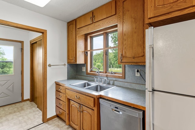 1231 135th St, Amery, WI 54005 - kitchen with freestanding refrigerator, dishwasher, light countertops, and brown cabinetry