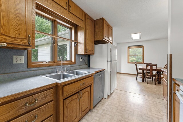 1231 135th St, Amery, WI 54005 - kitchen featuring stainless steel dishwasher, brown cabinetry, light countertops, and stove