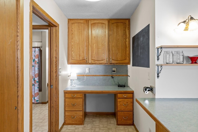 1231 135th St, Amery, WI 54005 - kitchen with brown cabinetry, a desk, light countertops, and a textured ceiling