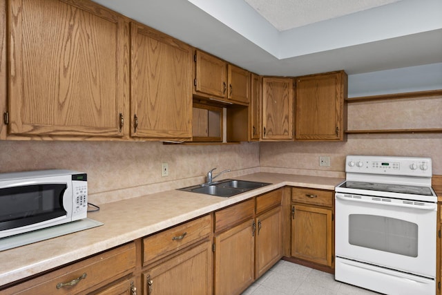 1231 135th St, Amery, WI 54005 - kitchen with white appliances, light countertops, brown cabinets, and light tile patterned floors