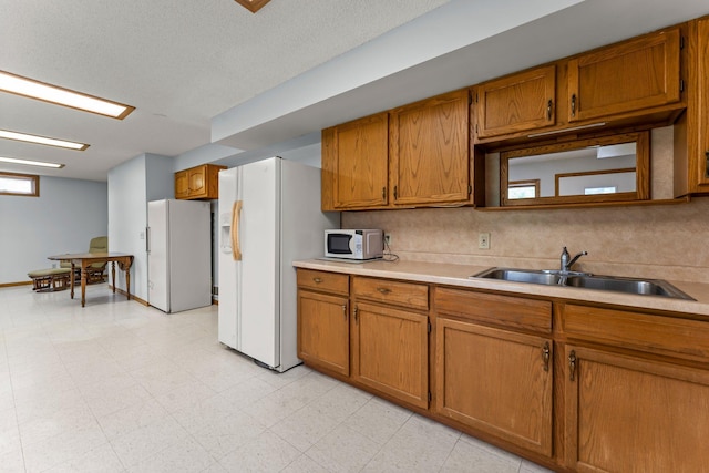 1231 135th St, Amery, WI 54005 - kitchen featuring white appliances, brown cabinets, and light countertops