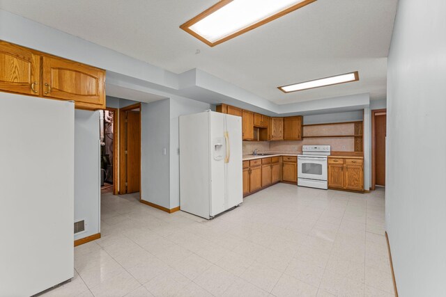 1231 135th St, Amery, WI 54005 - kitchen featuring white appliances, light countertops, and brown cabinets