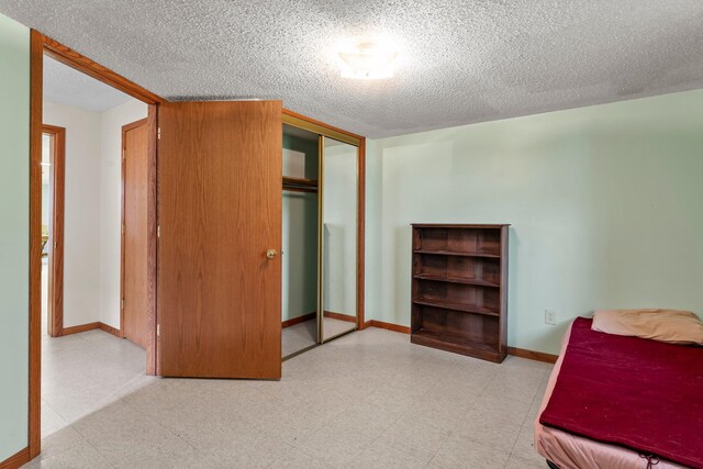 1231 135th St, Amery, WI 54005 - bedroom featuring tile patterned floors, a closet, and a textured ceiling