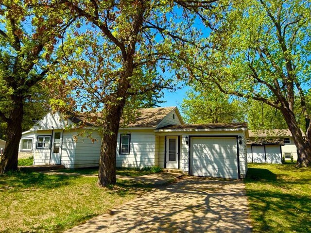 65 6th Ave S, Motley, MN 56466 - view of front of home with asphalt driveway, an attached garage, and a front lawn