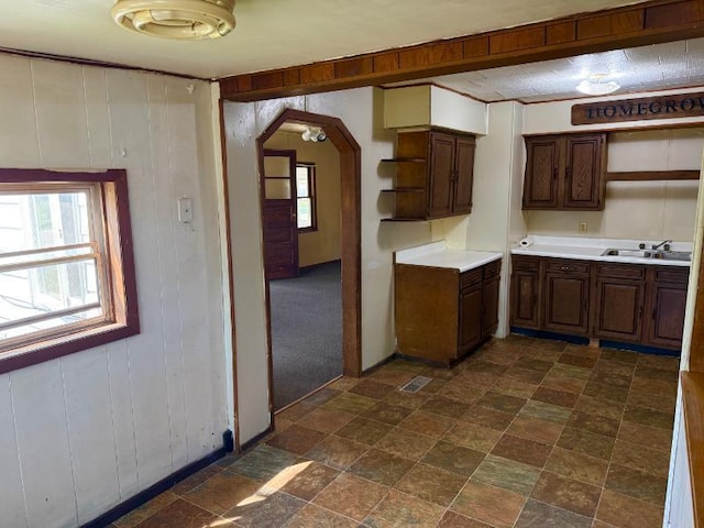65 6th Ave S, Motley, MN 56466 - kitchen with open shelves, plenty of natural light, arched walkways, light countertops, and wooden walls