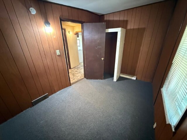65 6th Ave S, Motley, MN 56466 - unfurnished bedroom featuring wood walls and carpet flooring
