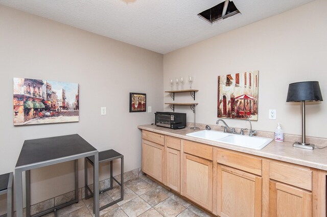 207 5th Ave SW Unit 901, Rochester, MN 55902 - kitchen featuring a sink, light brown cabinetry, light countertops, open shelves, and stone finish floors