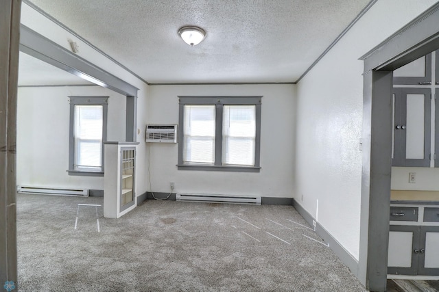 1010 University Dr N, Fargo, ND 58102 - unfurnished room with a baseboard radiator, carpet floors, a textured ceiling, and a wall unit AC