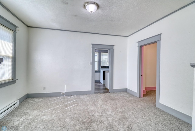 1010 University Dr N, Fargo, ND 58102 - spare room featuring baseboard heating, carpet floors, a textured ceiling, and baseboards