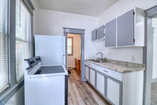 1010 University Dr N, Fargo, ND 58102 - kitchen with range with electric cooktop, freestanding refrigerator, a sink, light wood-style flooring, and light countertops