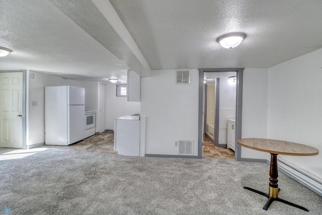 1010 University Dr N, Fargo, ND 58102 - basement featuring freestanding refrigerator, a textured ceiling, carpet floors, baseboard heating, and baseboards