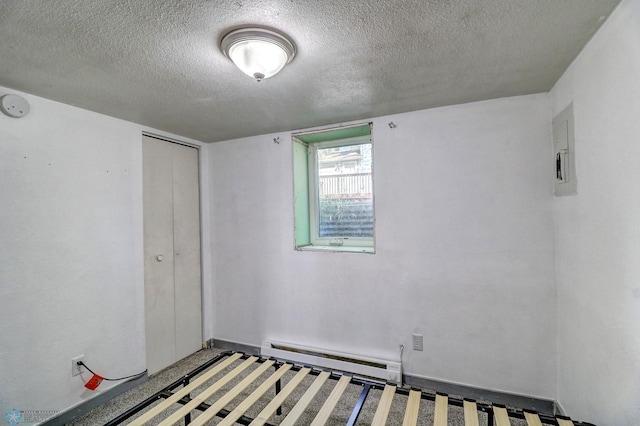 1010 University Dr N, Fargo, ND 58102 - unfurnished bedroom featuring baseboard heating, a textured ceiling, electric panel, and a closet