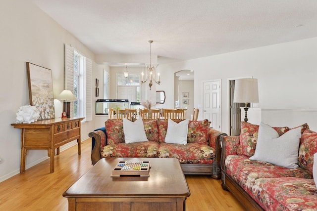 4555 Jewel Ln N, Plymouth, MN 55446 - living area with light wood finished floors, arched walkways, and a chandelier