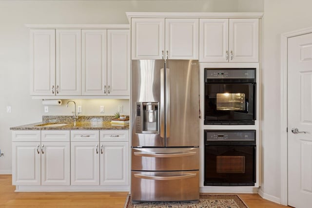4555 Jewel Ln N, Plymouth, MN 55446 - kitchen featuring stainless steel fridge, a sink, stone countertops, white cabinetry, and light wood-style floors