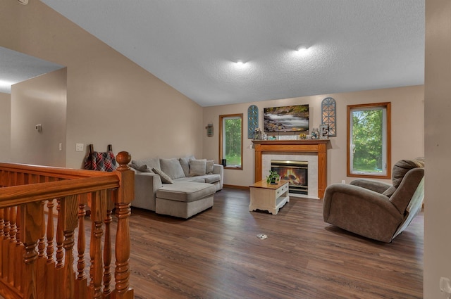 16474 63rd St SE, Becker, MN 55308 - living area featuring dark wood-style floors, a tiled fireplace, vaulted ceiling, and a textured ceiling