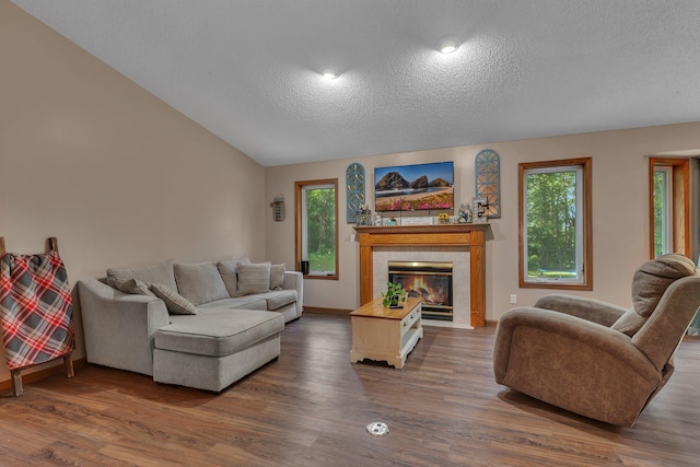 16474 63rd St SE, Becker, MN 55308 - living area with a textured ceiling, wood finished floors, a tiled fireplace, and lofted ceiling