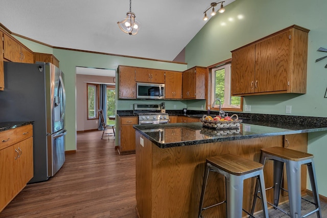 16474 63rd St SE, Becker, MN 55308 - kitchen with appliances with stainless steel finishes, brown cabinetry, a peninsula, dark wood-style flooring, and high vaulted ceiling