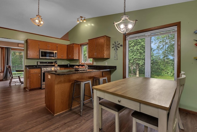 16474 63rd St SE, Becker, MN 55308 - kitchen featuring appliances with stainless steel finishes, vaulted ceiling, brown cabinets, dark countertops, and a chandelier