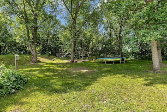16474 63rd St SE, Becker, MN 55308 - view of grassy yard with a trampoline and a playground