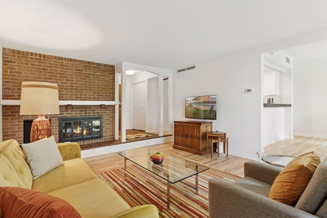 6085 Lincoln Dr Unit 123, Edina, MN 55436 - living area with wood finished floors, a brick fireplace, arched walkways, and baseboards