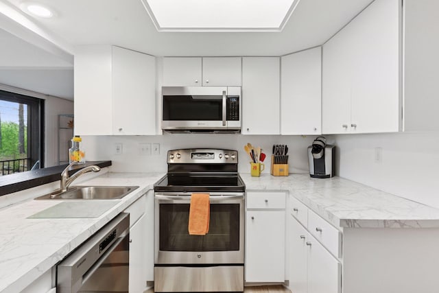 6085 Lincoln Dr Unit 123, Edina, MN 55436 - kitchen with stainless steel appliances, a sink, white cabinetry, and light countertops