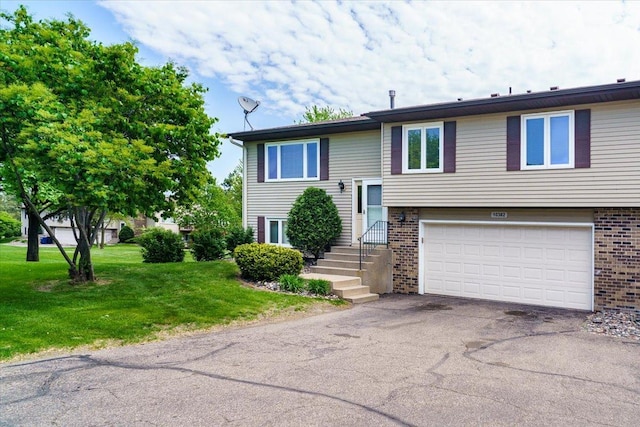 10382 Juniper Ln, Eden Prairie, MN 55347 - split foyer home featuring a garage, brick siding, driveway, and a front yard