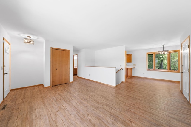 39094 Riverside Ct, North Branch, MN 55056 - unfurnished room with a chandelier, light wood-style floors, and baseboards