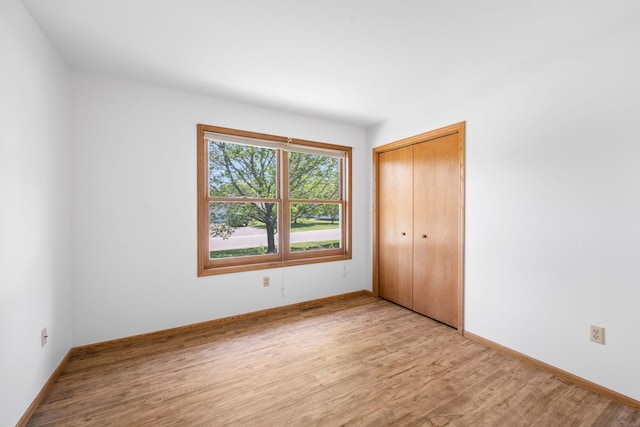 39094 Riverside Ct, North Branch, MN 55056 - unfurnished bedroom with light wood-style flooring, baseboards, and a closet