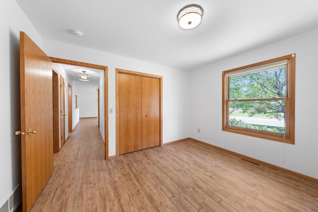 39094 Riverside Ct, North Branch, MN 55056 - unfurnished bedroom featuring light wood-style floors, a closet, and baseboards