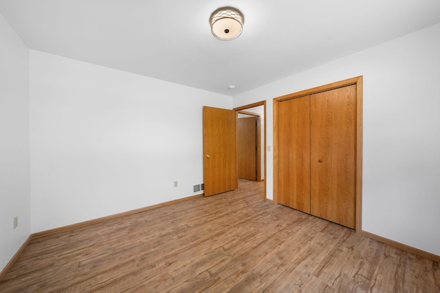 39094 Riverside Ct, North Branch, MN 55056 - unfurnished bedroom featuring light wood-style flooring, a closet, and baseboards