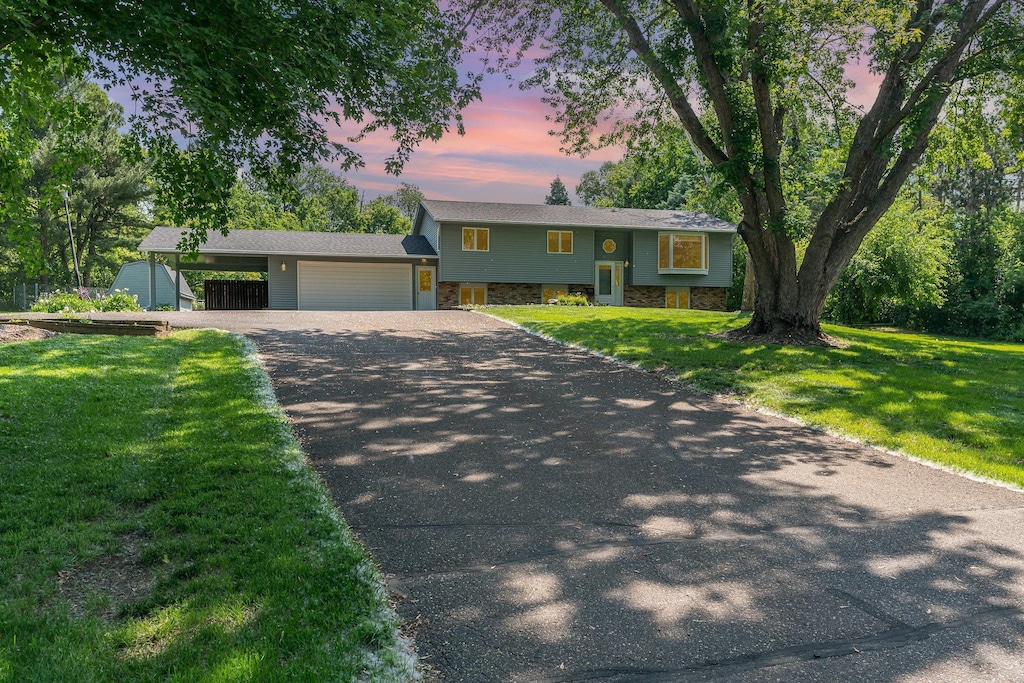 897 Willow Ridge Rd, Hudson, WI 54016 - raised ranch with driveway, a lawn, stone siding, a garage, and a carport