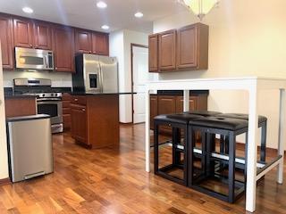 1595 Fox Hunt Way, Victoria, MN 55386 - kitchen featuring stainless steel appliances, recessed lighting, wood finished floors, dark countertops, and a center island
