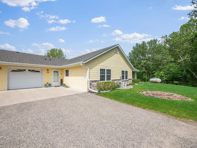 116 Street Cir Unit 104, Miltona, MN 56354 - ranch-style home featuring driveway, a garage, stone siding, a front yard, and roof with shingles