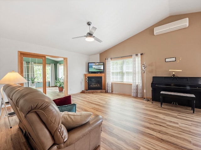 116 Street Cir Unit 104, Miltona, MN 56354 - living room with a wall unit AC, lofted ceiling, light wood-style flooring, a glass covered fireplace, and a ceiling fan