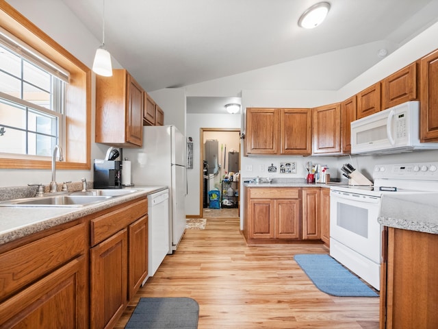 116 Street Cir Unit 104, Miltona, MN 56354 - kitchen with white appliances, a sink, vaulted ceiling, brown cabinets, and light wood-style flooring