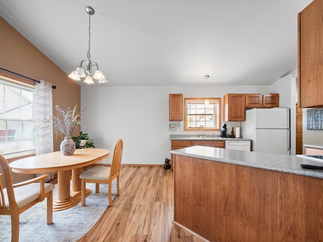 116 Street Cir Unit 104, Miltona, MN 56354 - kitchen featuring white appliances, vaulted ceiling, brown cabinets, a chandelier, and light wood finished floors