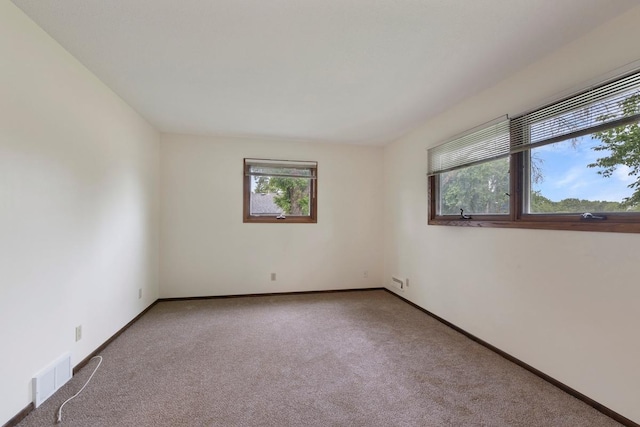 spare room featuring carpet floors and baseboards