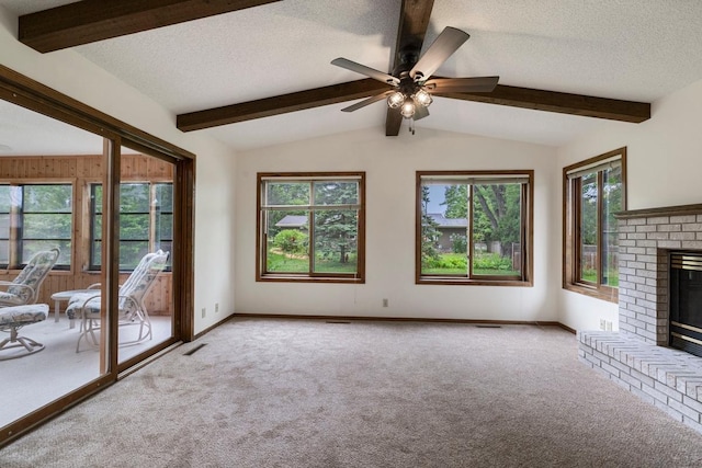 unfurnished living room featuring carpet, a textured ceiling, a brick fireplace, a ceiling fan, and baseboards