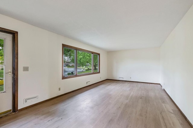unfurnished room with plenty of natural light, light wood-style flooring, and baseboards