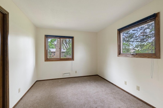 unfurnished room with healthy amount of natural light, carpet floors, and baseboards