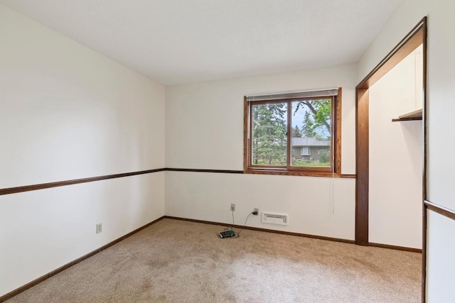 carpeted empty room with baseboards
